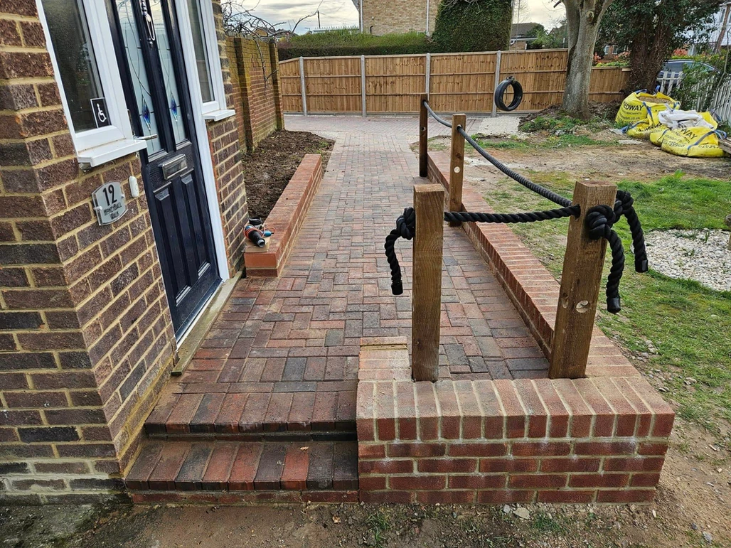 a brick walkway with a fence and a rope