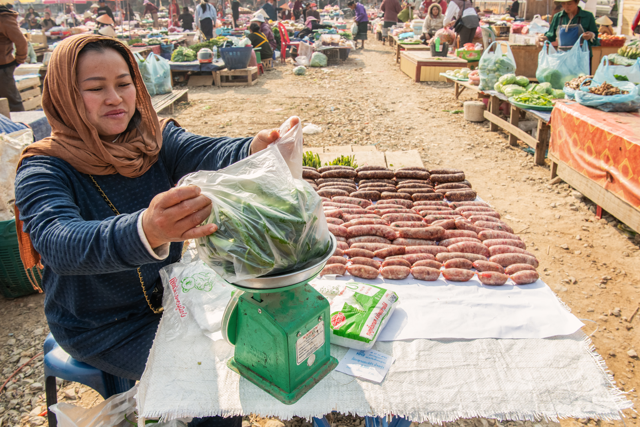 a woman weighing vegetables at a market