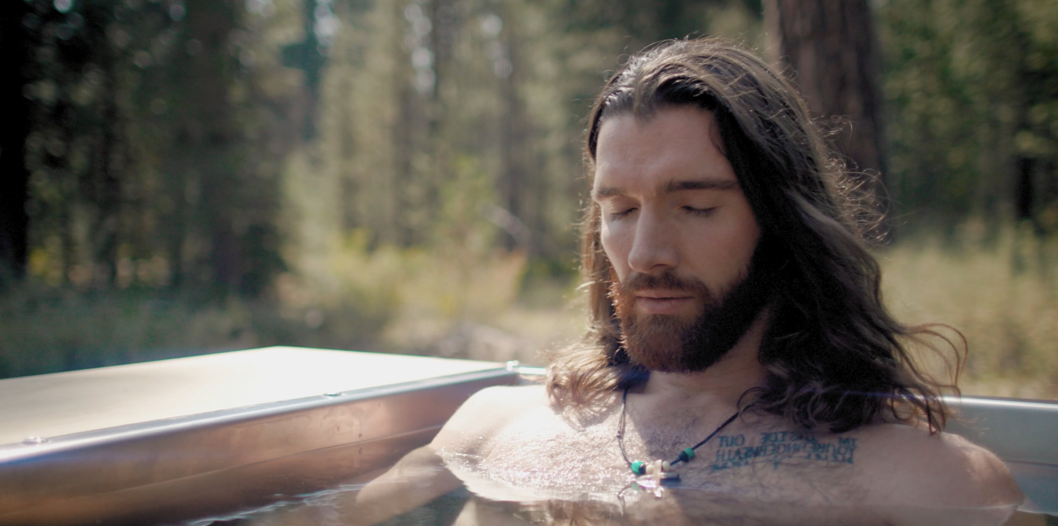 a man with long hair and beard in a hot tub