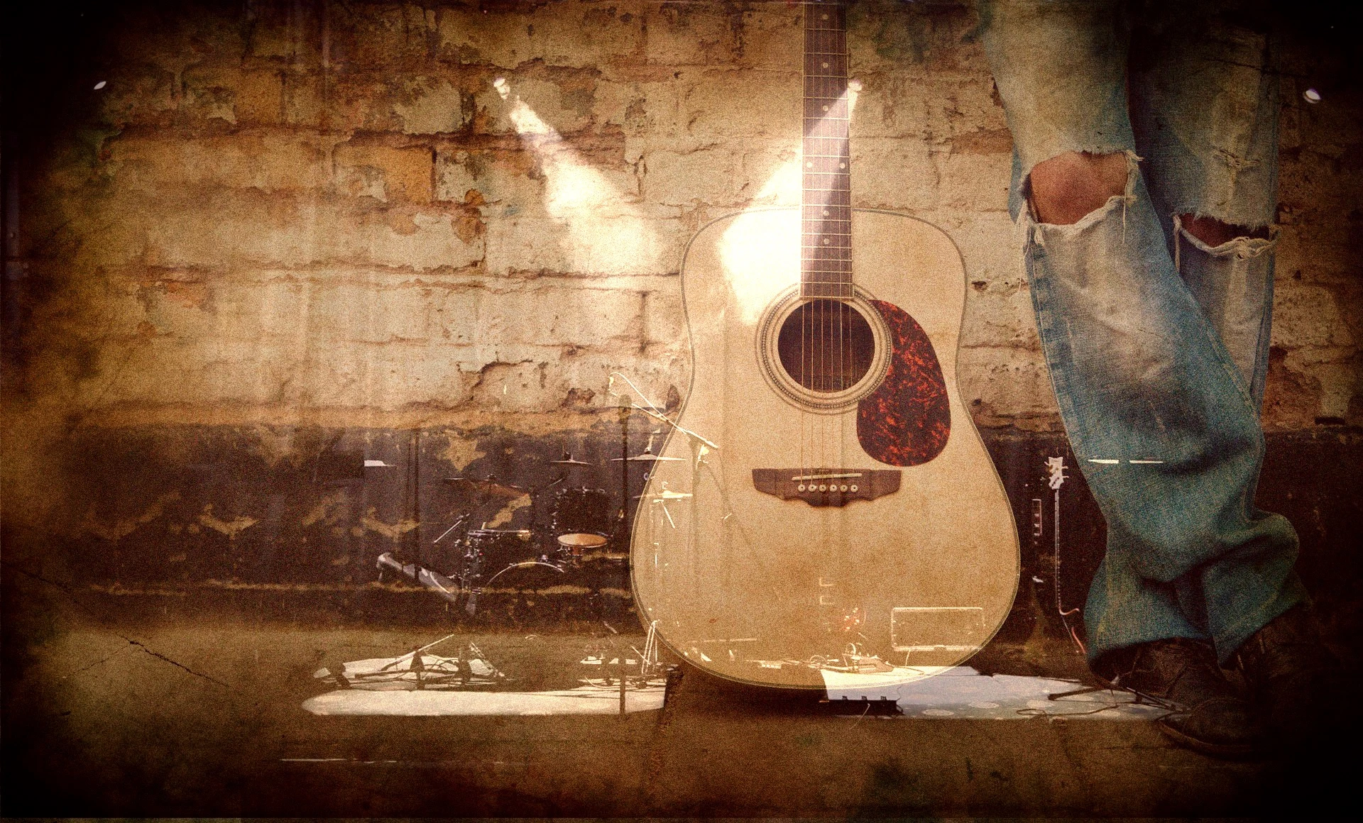 a guitar in front of a brick wall