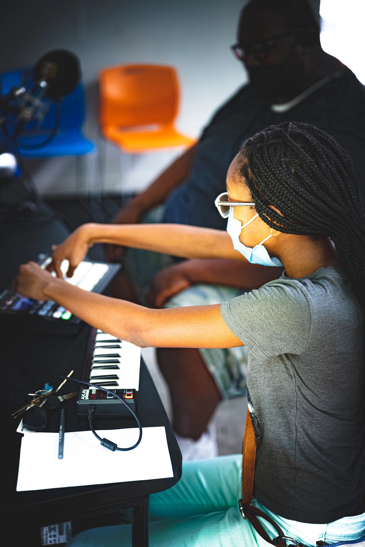 a girl wearing a mask and sitting at a keyboard