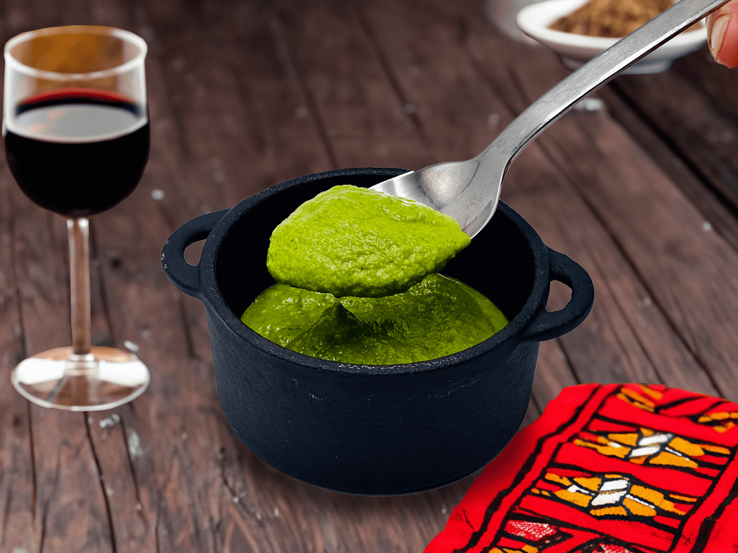 a spoon in a pot of green sauce