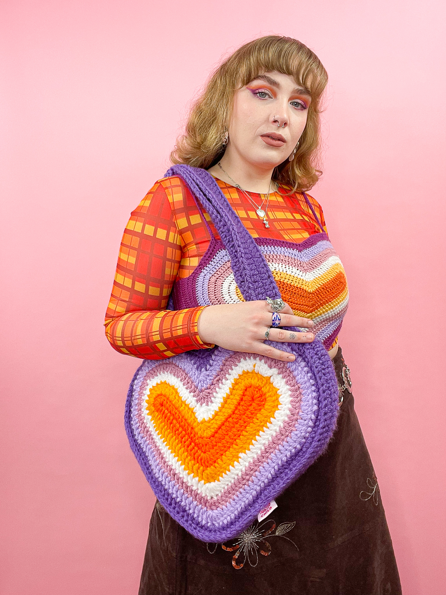 a woman holding a knitted bag