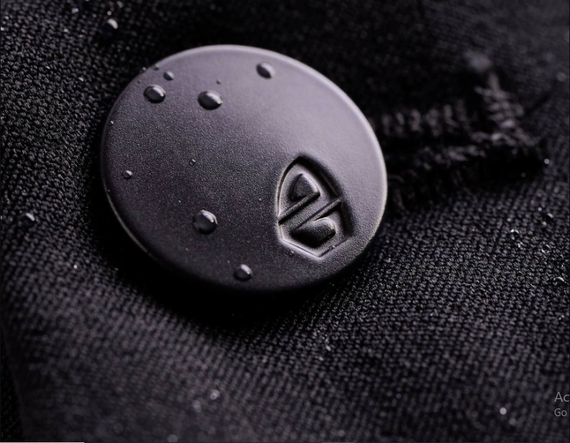 a black button with water droplets on it