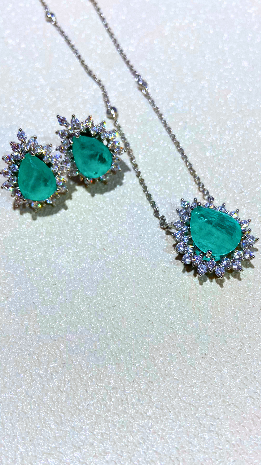 a pair of emerald earrings and necklaces