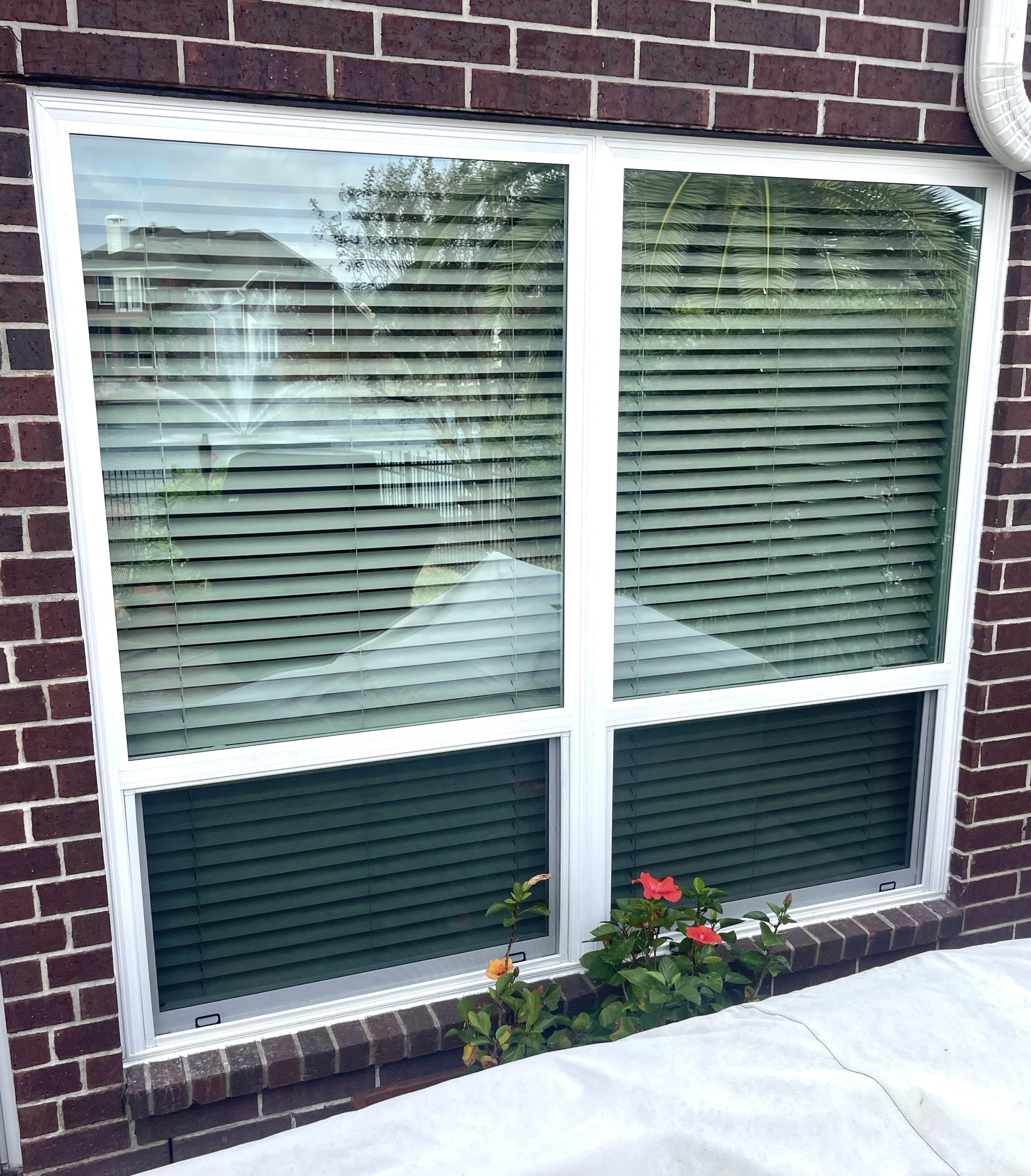 a window with blinds on the side of a brick building