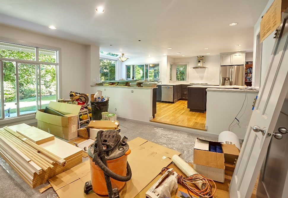 a room with a kitchen and a vacuum cleaner