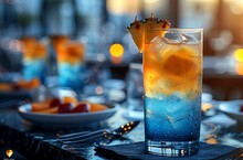 a glass of blue and orange drink with a slice of pineapple on top