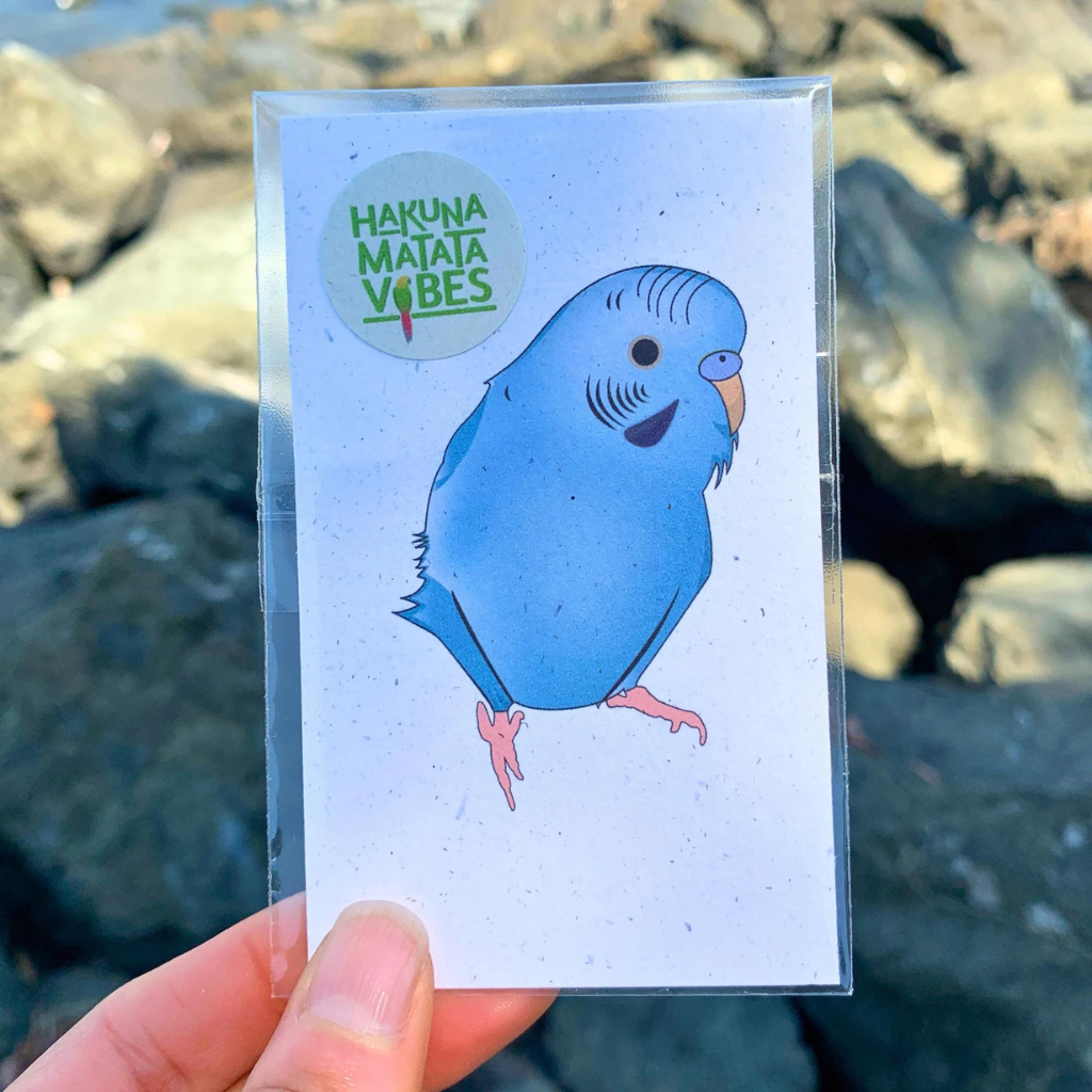 a hand holding a card with a blue bird on it