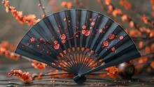 a black fan with red flowers