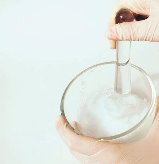 a person holding a glass bowl with a pipette