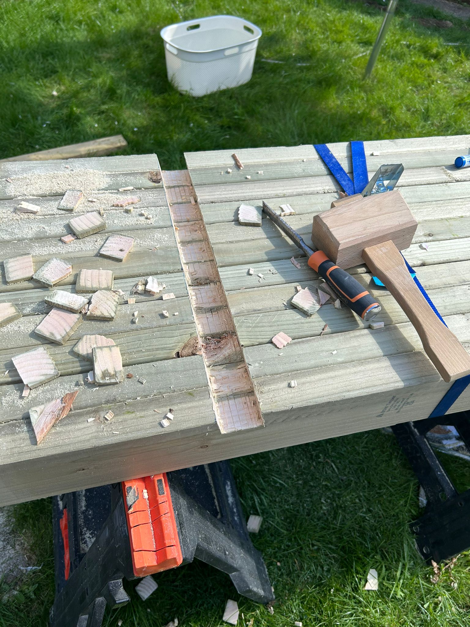 a wood plank with a hammer and a screwdriver on it