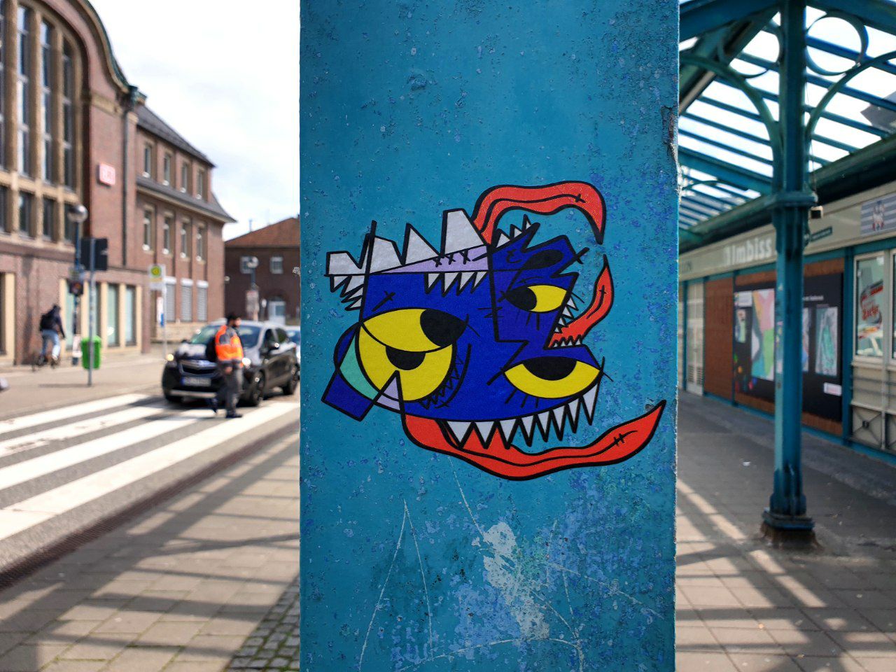 a blue pillar with graffiti on it