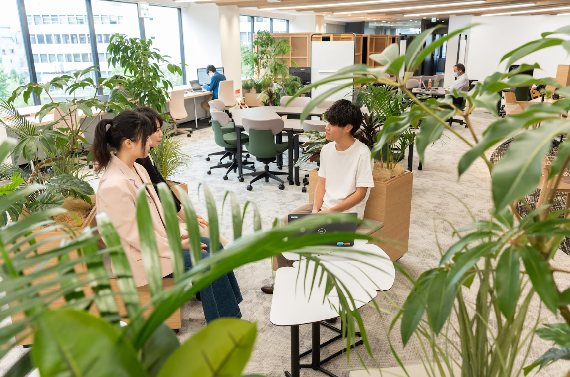 people sitting in a room with plants