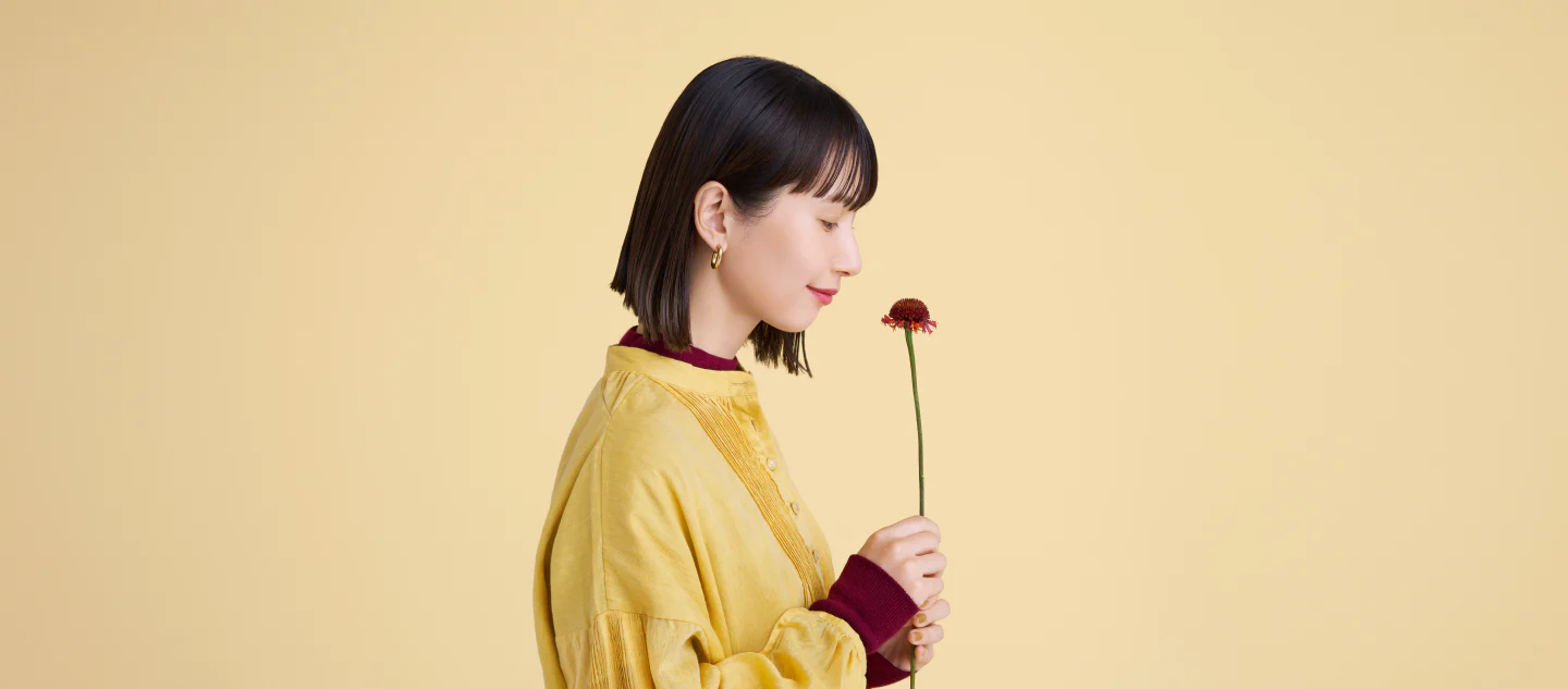 a woman smelling a flower