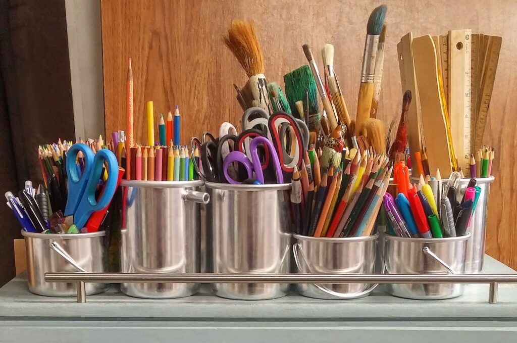 a group of pencils and scissors in a row