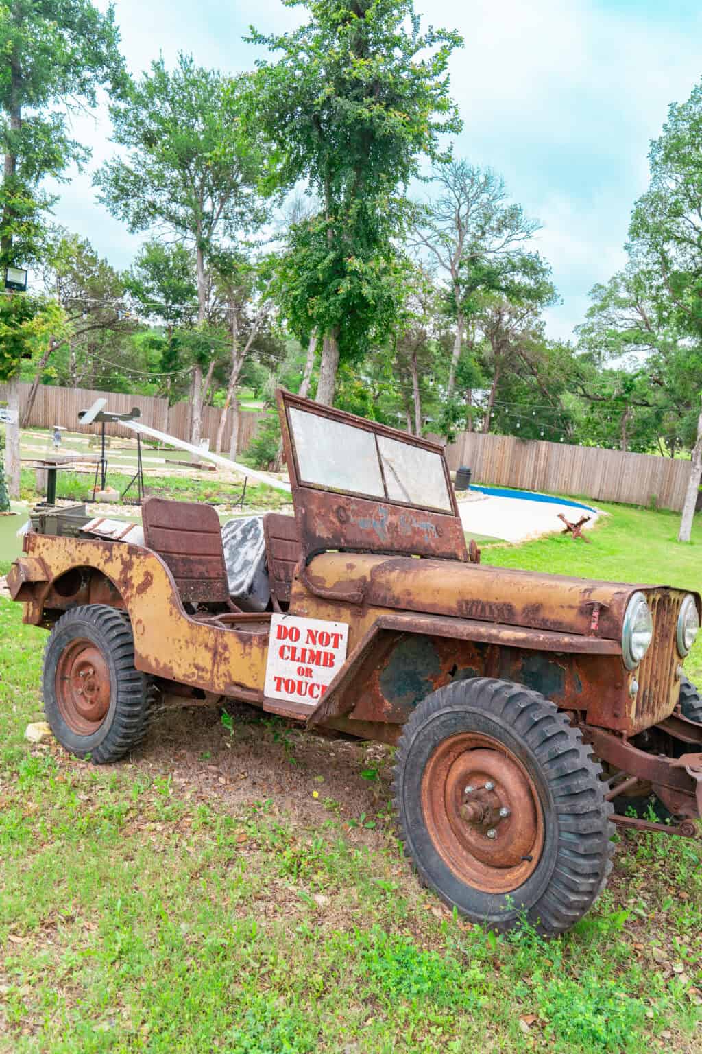 an old rusty jeep in a yard