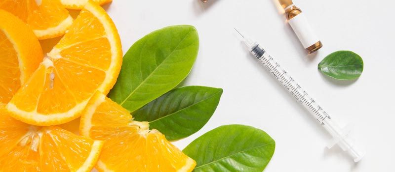 a syringe and oranges next to a syringe