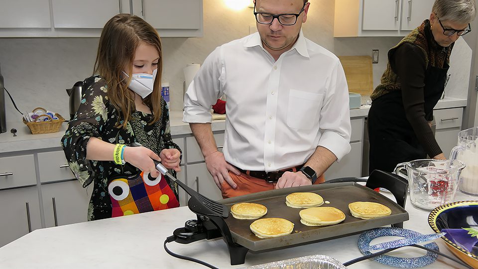 a group of people cooking pancakes
