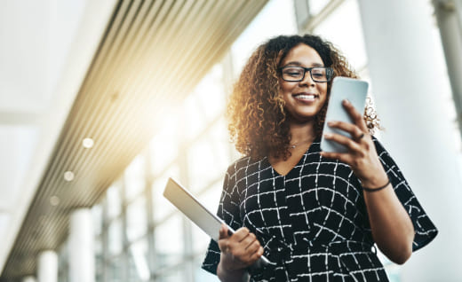 a woman holding a tablet and a phone