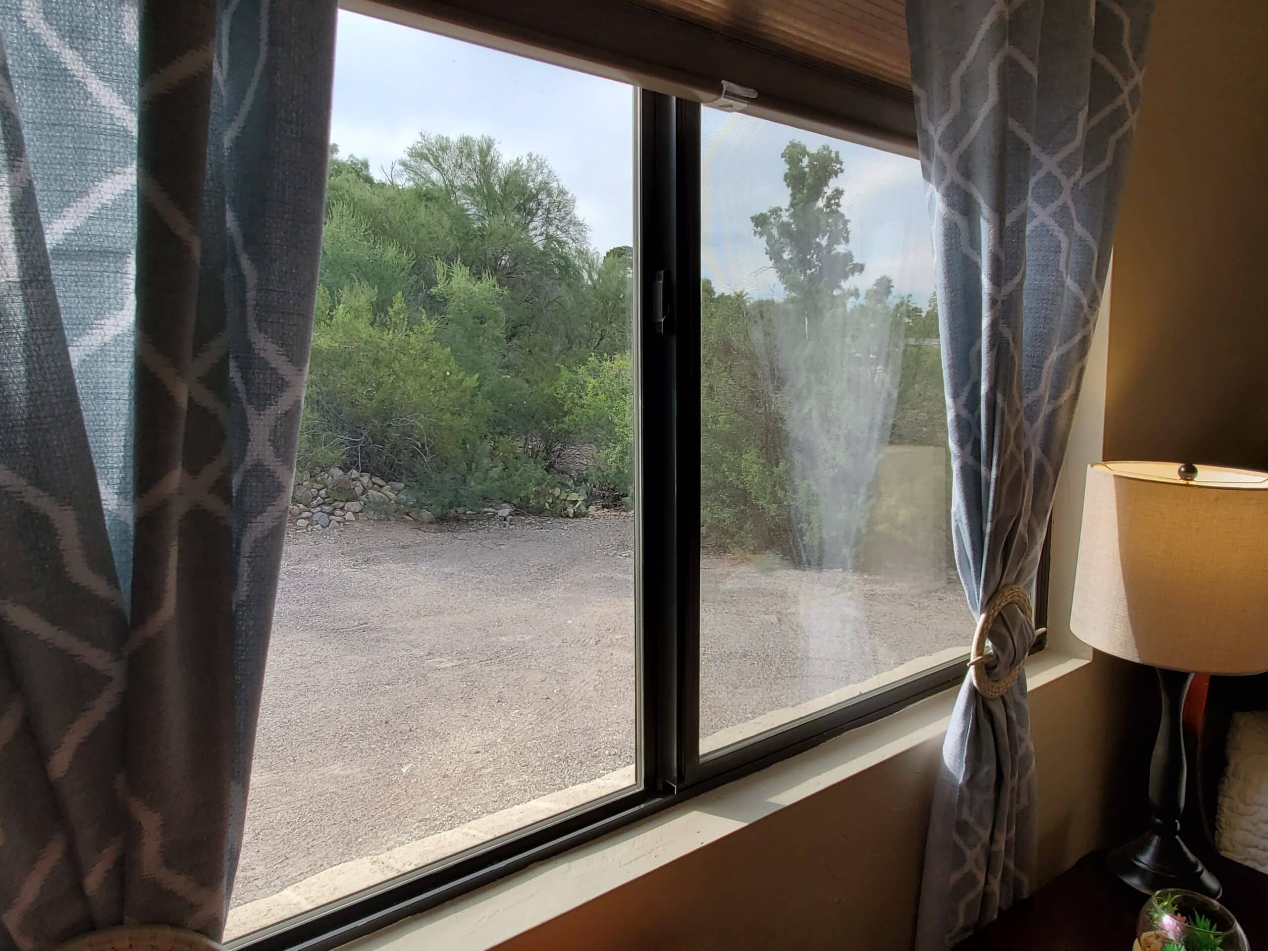 a window with a lamp and trees outside