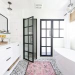 a bathroom with a pink rug and a tub