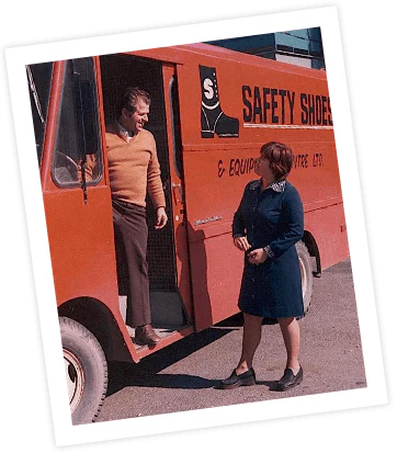 a man and woman standing in the door of a truck