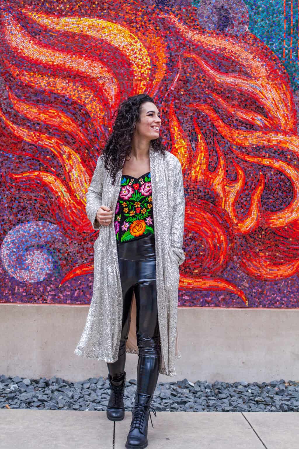 a woman smiling in front of a colorful wall