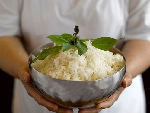 a person holding a bowl of rice