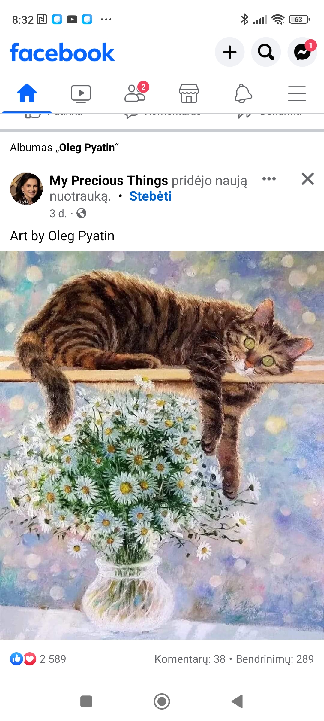 a cat lying on a ledge with a bouquet of flowers