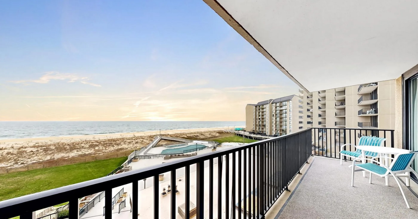 a balcony overlooking a beach and a body of water