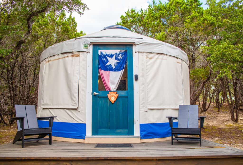 a white and blue yurt with a flag on the door