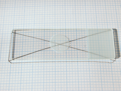 a transparent rectangular object with a circle and a black string