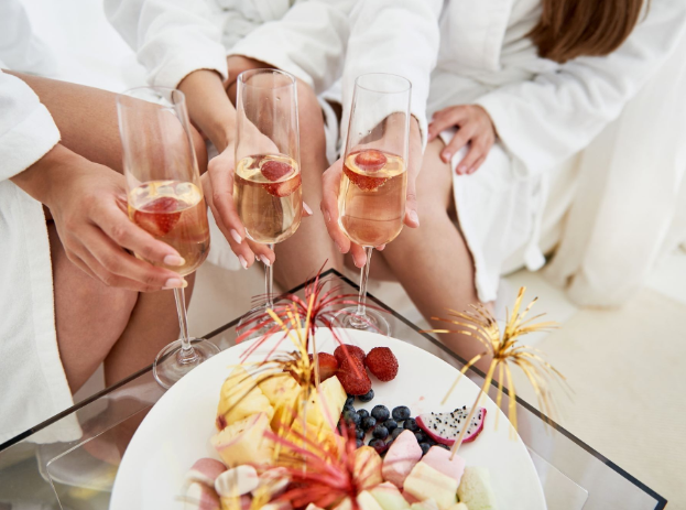 a group of people in white robes holding champagne glasses