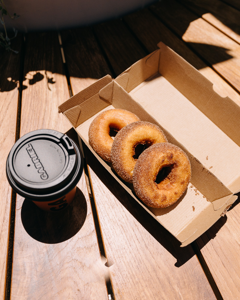 a box of donuts and a coffee cup on a table