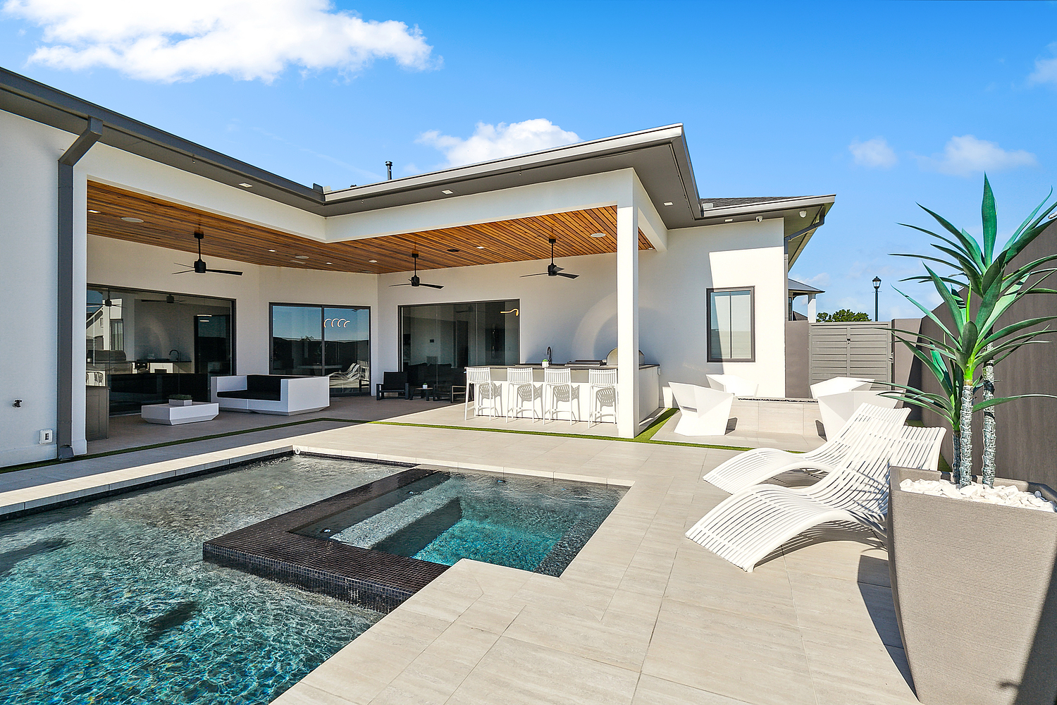 a pool and a house with a deck and chairs