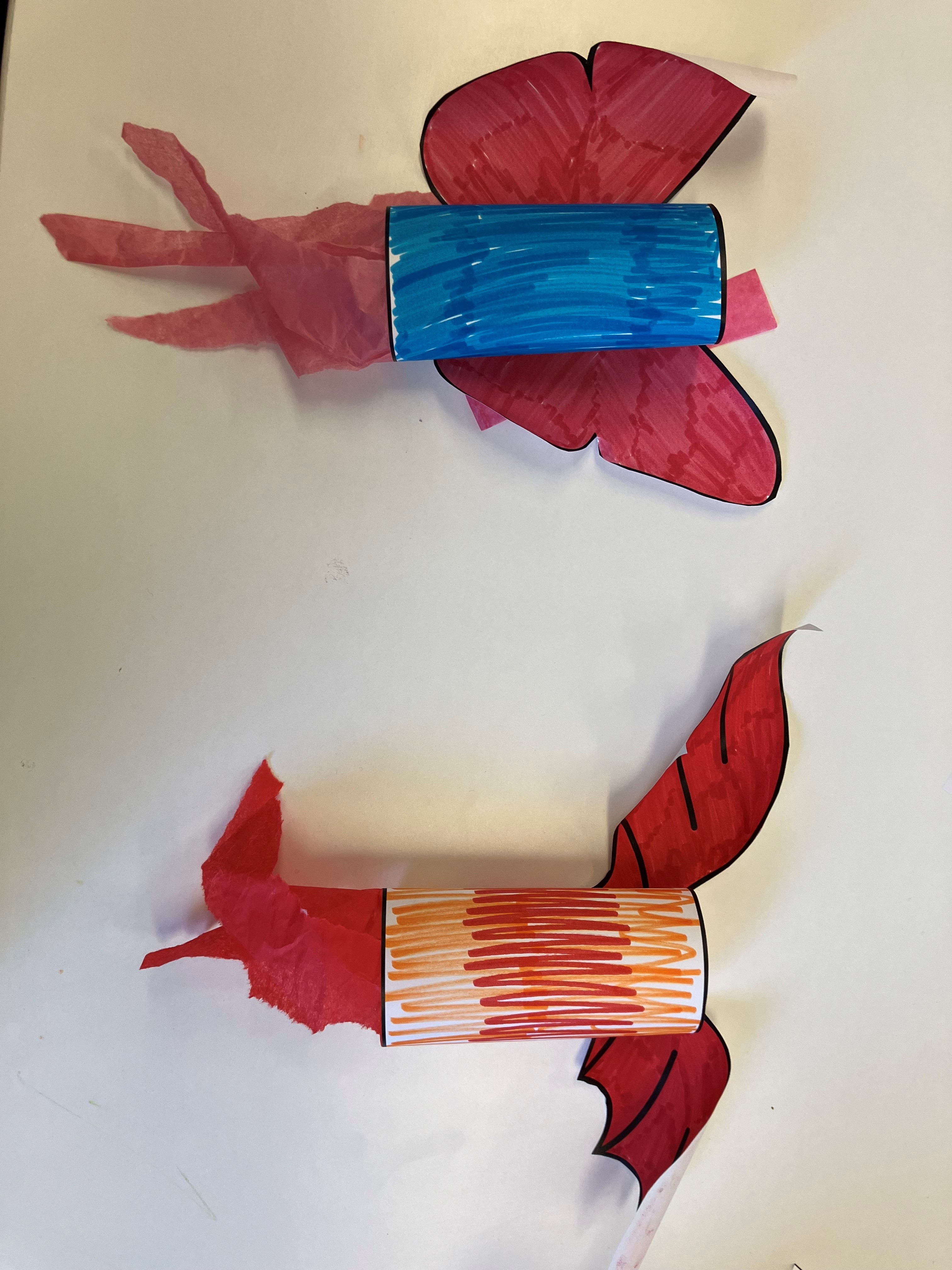 a paper roll craft with red and blue wings