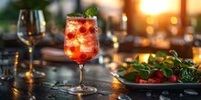 a glass of red liquid with berries and leaves on a table