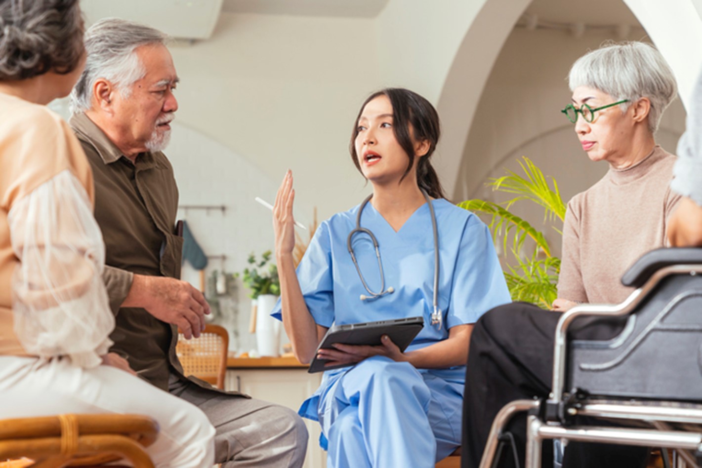 a nurse talking to a couple of elderly people