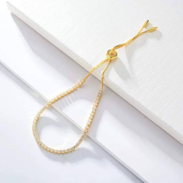 a gold bracelet with diamonds on a white surface
