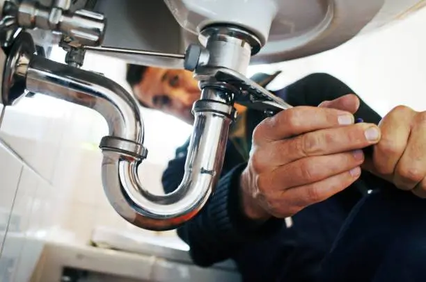 a close-up of a man fixing a sink