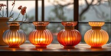 a group of orange glass objects with a lit candle