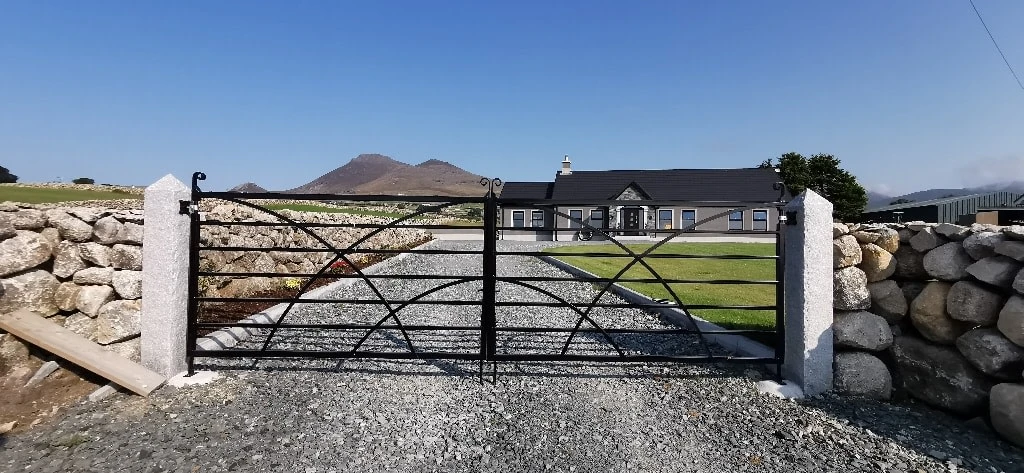 a gated driveway with a house in the background