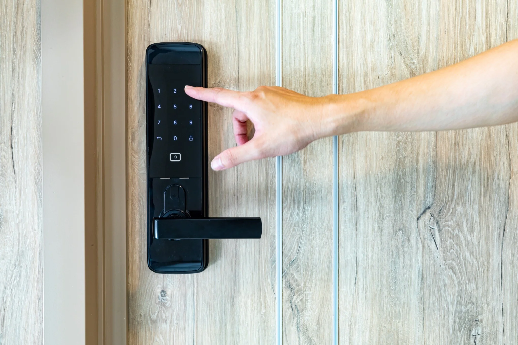 a hand pressing a keypad on a door