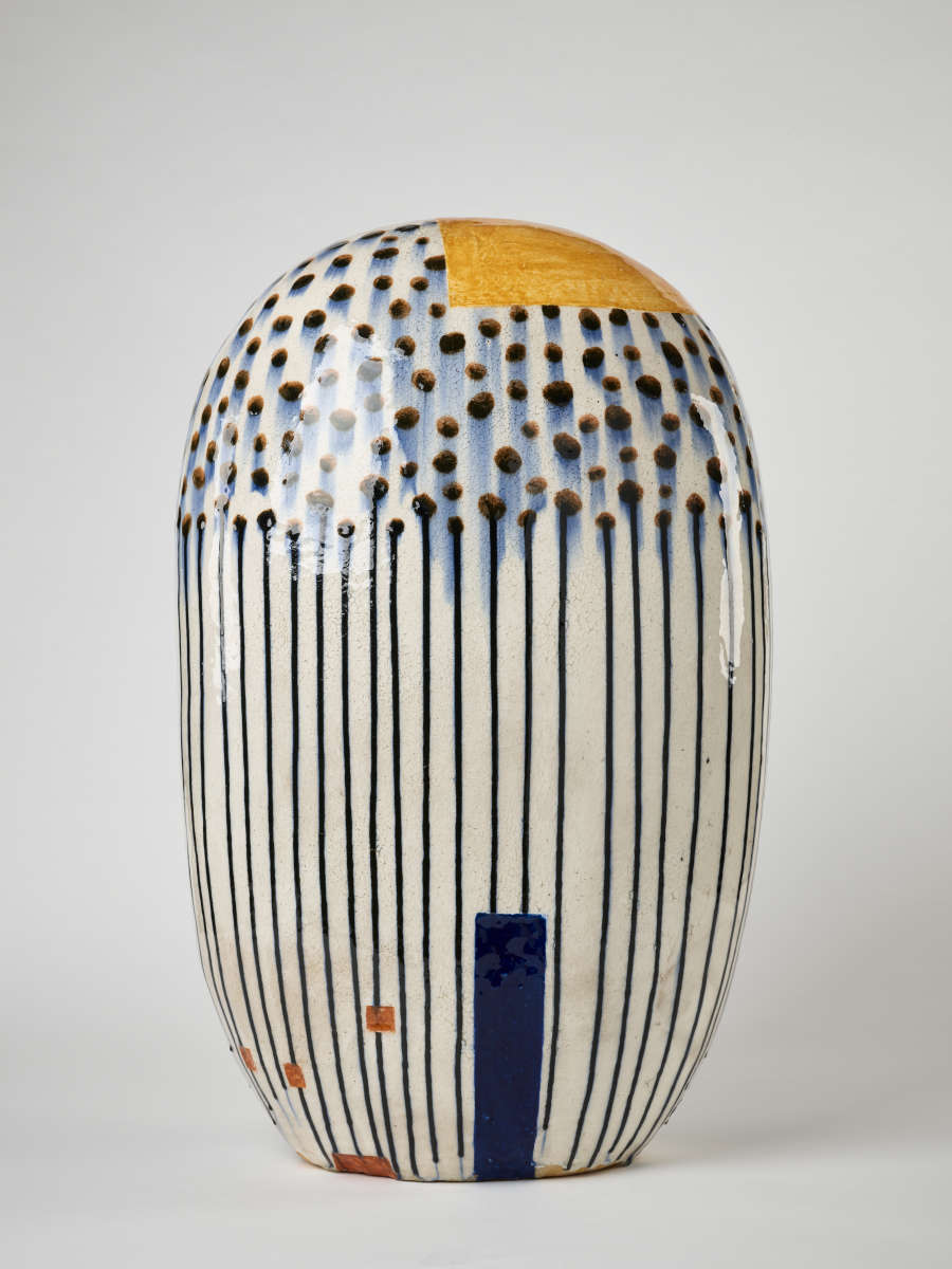 a white and blue vase with black and white stripes