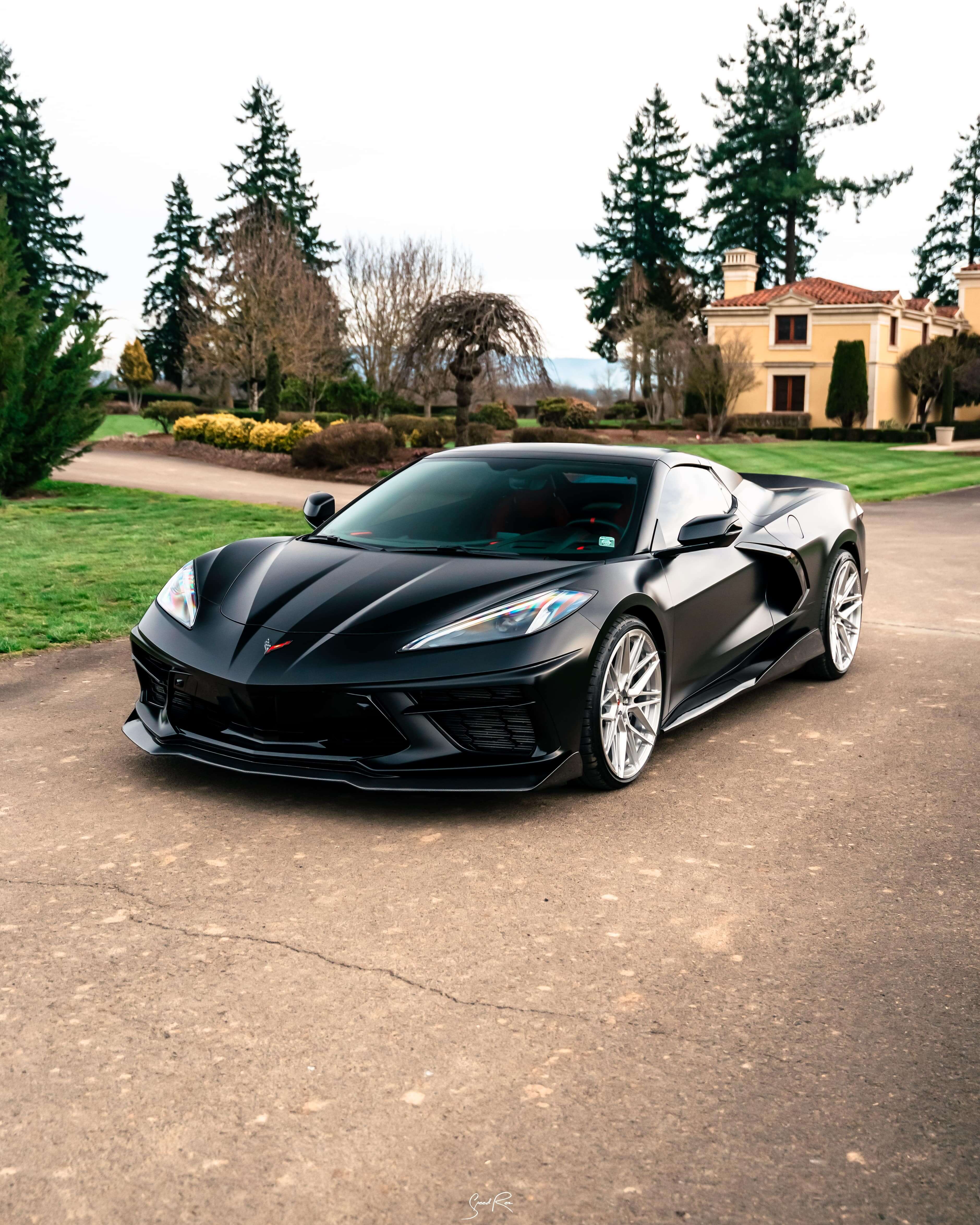 a black sports car parked on a driveway