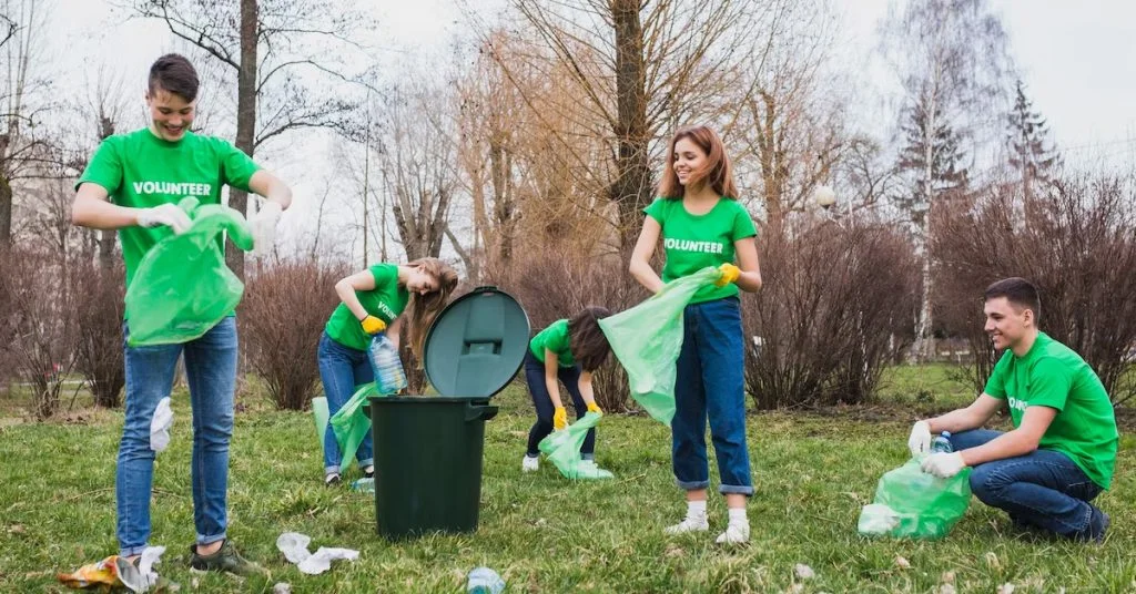 a group of people in green shirts picking up trash
