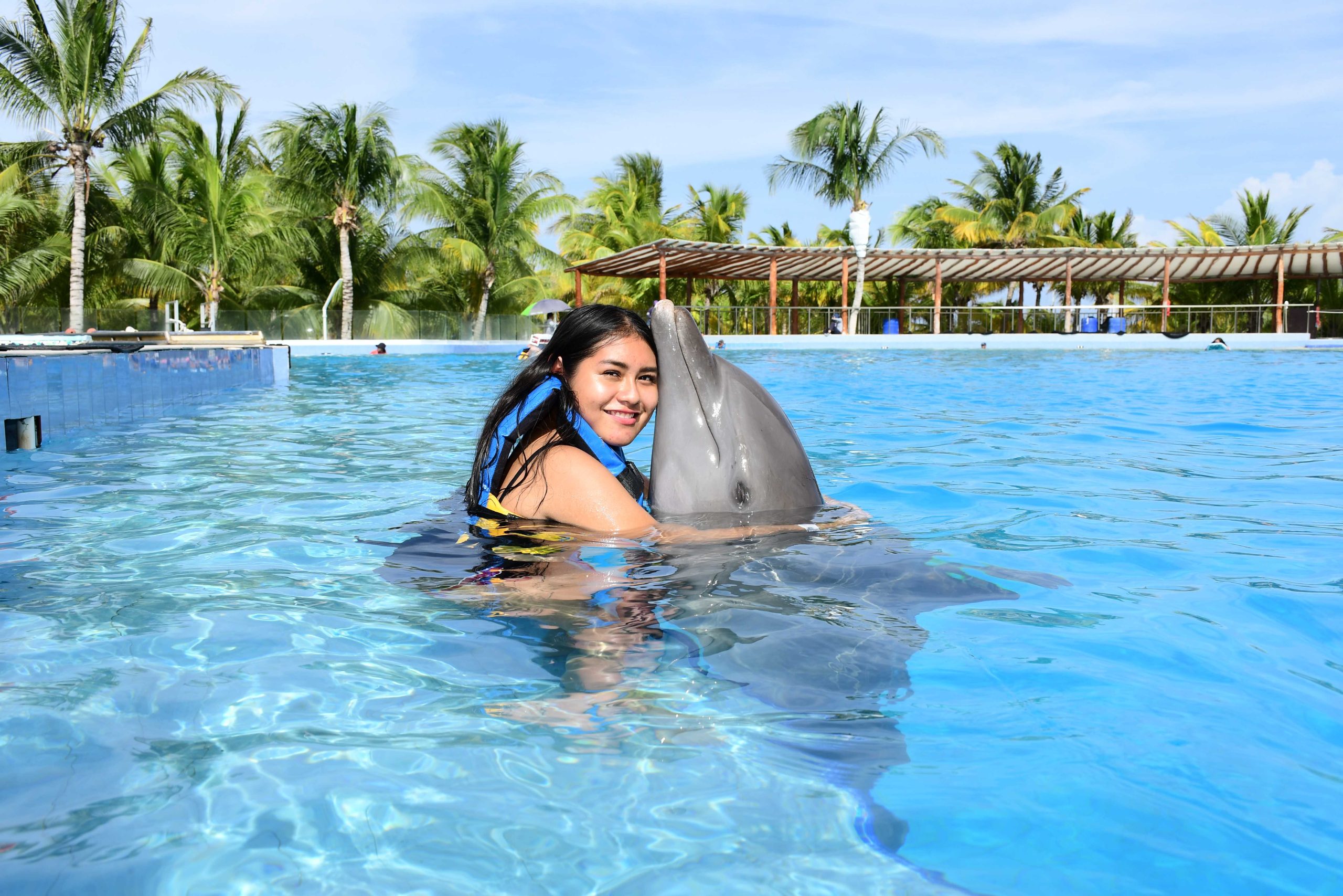 a woman hugging a dolphin in a pool