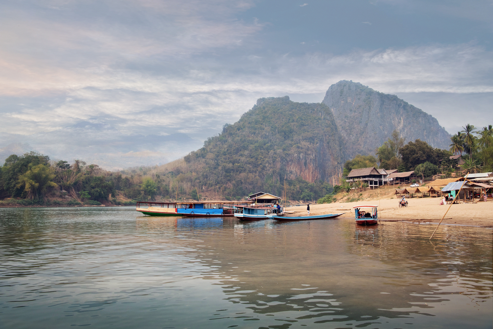 boats on a river with mountains in the background
