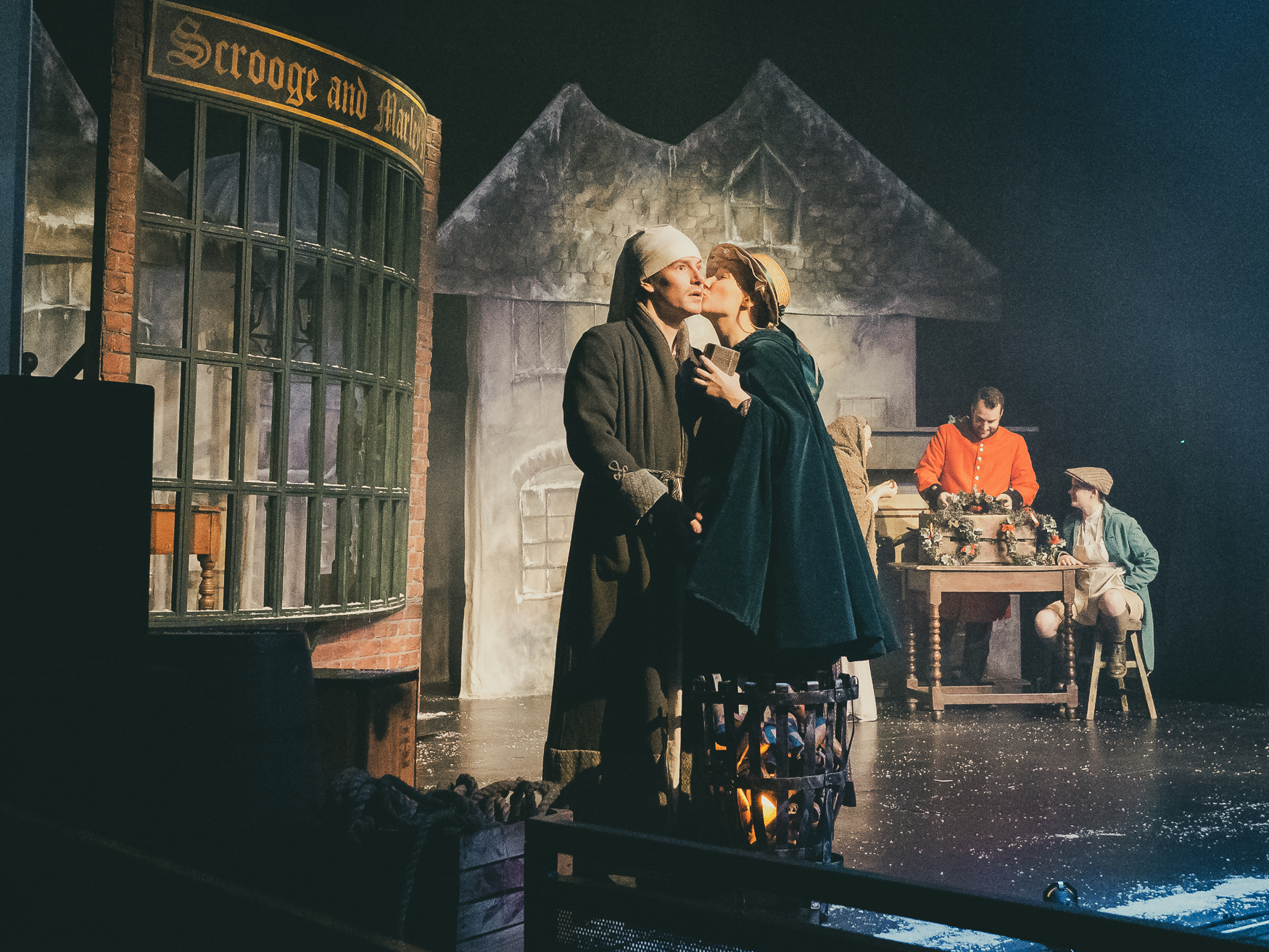 a man and woman kissing on a stage